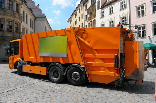 Workers handling commercial rubbish bins with protective gear during collection